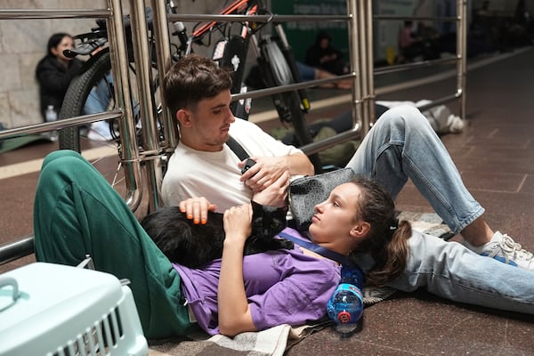 People rest in a metro station, being used as a bomb shelter, during a Russian attack in Kyiv, Ukraine, early Thursday, July 10, 2025. (AP Photo/Efrem Lukatsky)