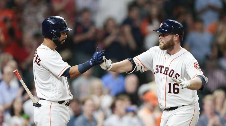 Brian McCann (right) is congratulated by Marwin Gonzalez after hitting a home run against Seattle earlier this season. BOB LEVEY/GETTY IMAGES