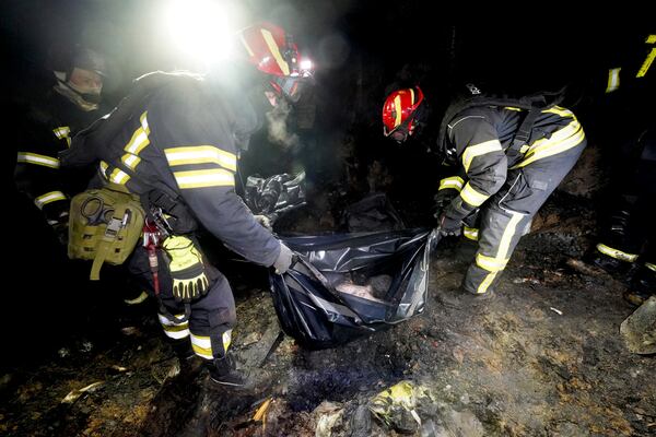 Rescue workers collect the body parts of a person killed in a Russian strike on a residential neighborhood of Kharkiv, Ukraine, Saturday, March 29, 2025. (AP Photo/Andrii Marienko)