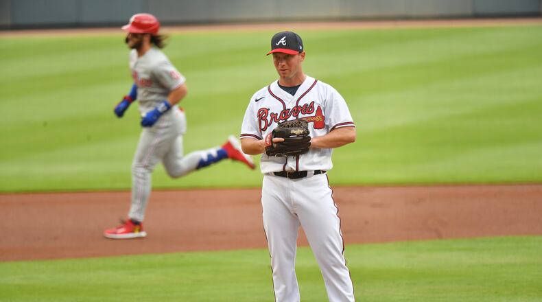 Braves pitcher Robbie Erlin (49) reacts after he allowed a two-run home run by Philadelphia Phillies right fielder Bryce Harper (background) during the first inning at Truist Park on Saturday, August 22, 2020. (Hyosub Shin / Hyosub.Shin@ajc.com)
