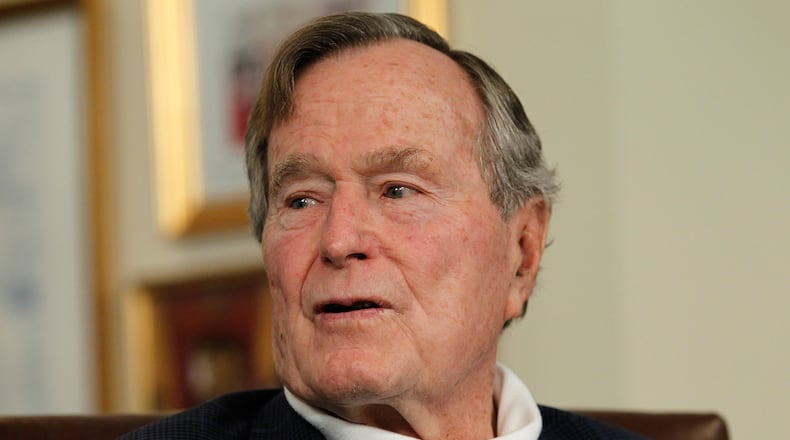 Former President George H.W. Bush talks with Republican presidential candidate, former Massachusetts Gov. Mitt Romney at Bush's office on March 29, 2012 in Houston, Texas. (Photo by Tom Pennington/Getty Images)