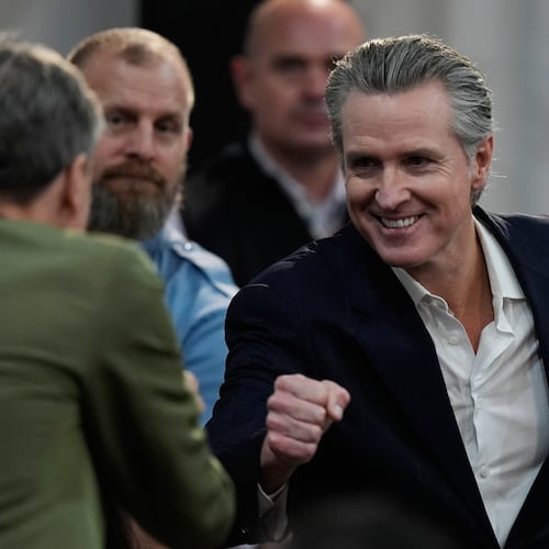 California Gov. Gavin Newsom, right, greets people as he arrives for a news conference at the COP30 U.N. Climate Summit, Tuesday, Nov. 11, 2025, in Belem, Brazil. (AP Photo/Fernando Llano)