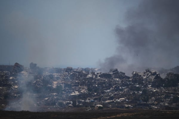 Smoke rises amid buildings that were destroyed during the Israeli ground and air operations in northern of Gaza Strip as seen from southern Israel, Friday, May 23, 2025. (AP Photo/Leo Correa)