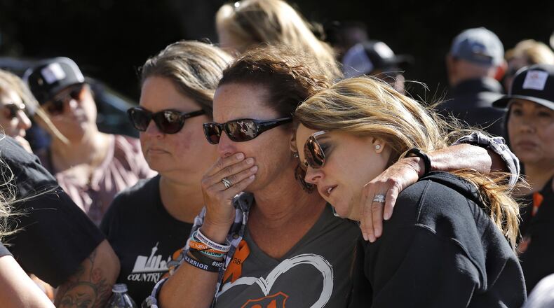 Jill Winter of San Diego (from left), Sue Heili of Foothill Ranch, Calif., and Kristy Hayhurst of Chino, Calif., gather with others at a makeshift memorial for victims of the mass shooting at the Borderline bar in Thousand Oaks, Calif., on Nov. 11. All three of them are survivors of the Route 91 Harvest country music festival mass shooting in Las Vegas in 2017. MEL MELCON / LOS ANGELES TIMES / TNS