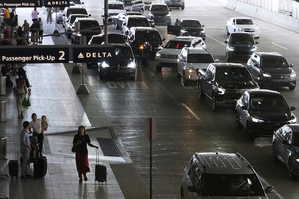 Travelers arrive and depart a terminal at Detroit Metropolitan Airport in Romulus, Mich., Thursday, July 3, 2025. (AP Photo/Paul Sancya)