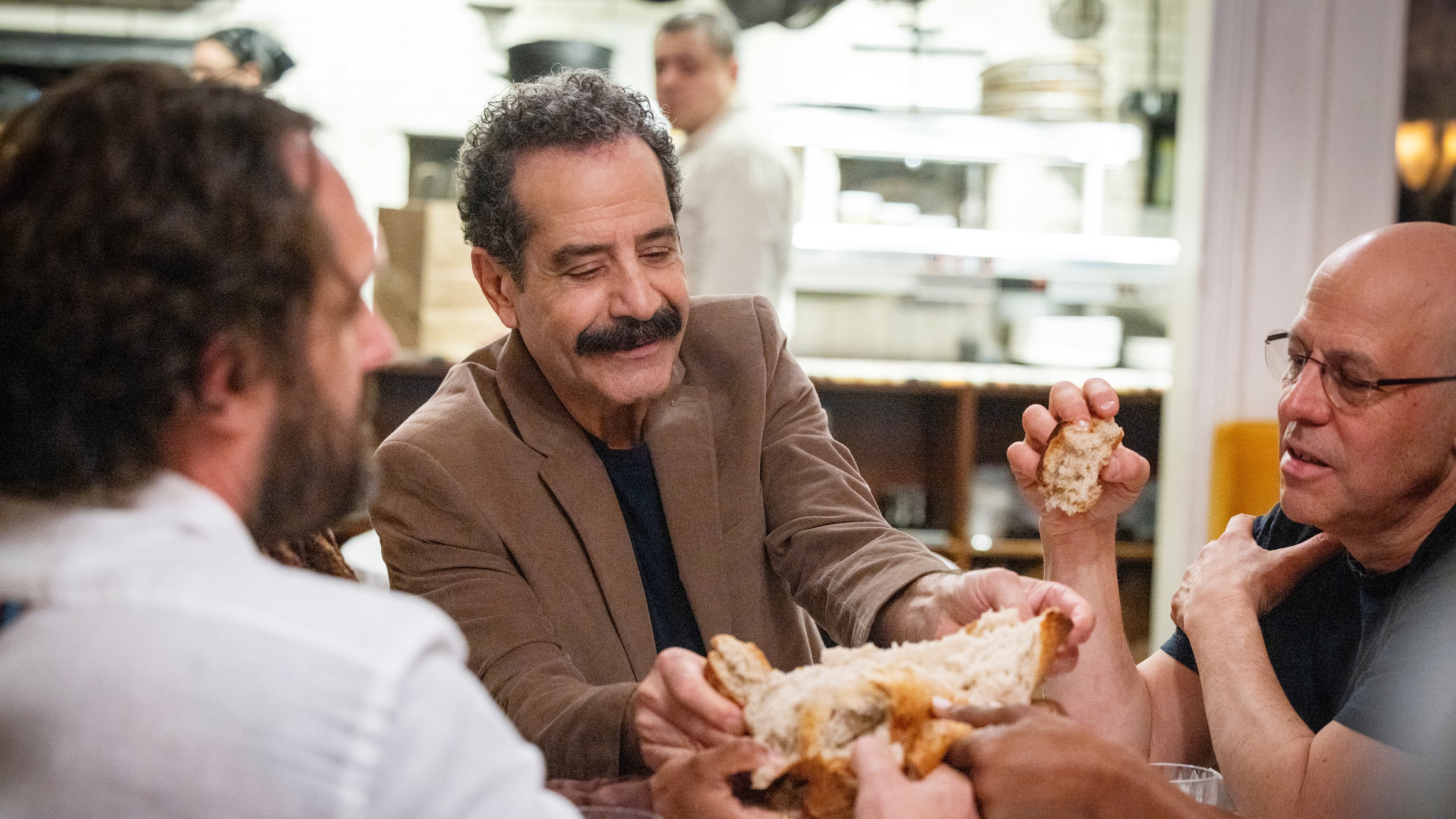 This image released by CNN shows Tony Shalhoub, center, in a scene from his series "Breaking Bread," which follows the actor across the globe as he explores cultures and food through the lens of bread. (CNN via AP)