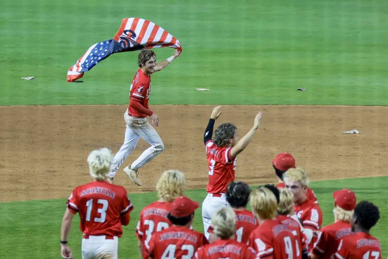Loganville’s Brantley Carter (2) runs with an American flag after hitting a walk-off single to win the game 4-3 against Pope in Game 3 of the Class 5A GHSA Baseball State Championship Series at Gwinnett Field on Tuesday, May 26, 2026, in Lawrenceville, Ga. Loganville won the series 2-1.(Miguel Martinez/AJC)