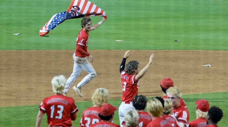 Loganville’s Brantley Carter runs with an American flag after driving home the winning run in a 4-3 victory over Pope in Game 3 of the Class 5A GHSA baseball state championship series at Gwinnett Field on May 26, 2026, in Lawrenceville. (Miguel Martinez/AJC)