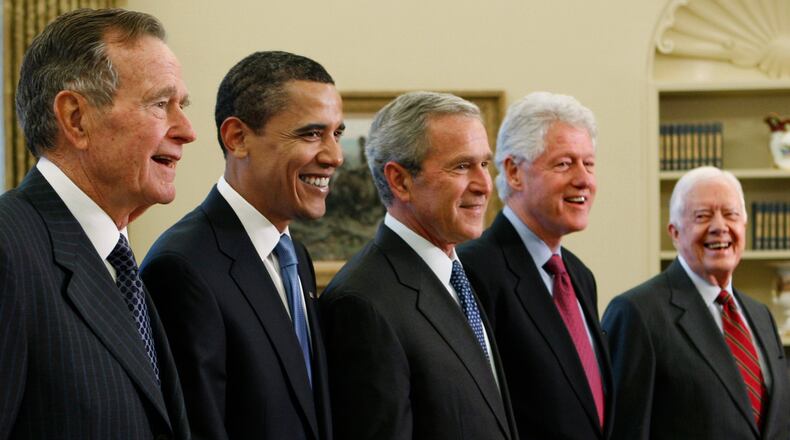 FILE - President George W. Bush, center, poses with President-elect Barack Obama, and former presidents, from left, George H.W. Bush, left, Bill Clinton and Jimmy Carter, right, Jan. 7, 2009, in the Oval Office of the White House in Washington. (AP Photo/J. Scott Applewhite, File)