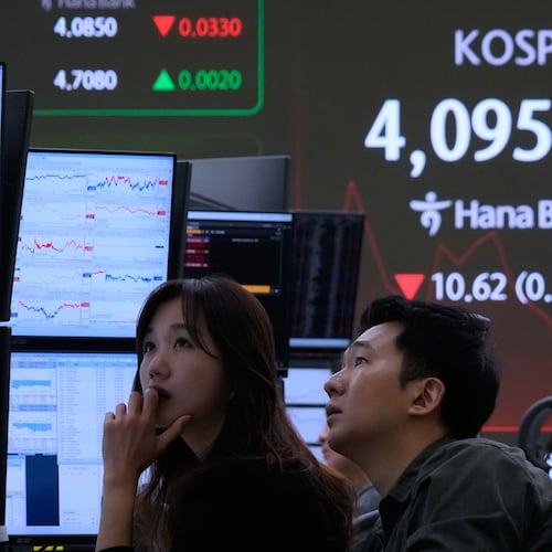 Currency traders watch monitors near a screen showing the Korea Composite Stock Price Index (KOSPI) at the foreign exchange dealing room of the Hana Bank headquarters in Seoul, South Korea, Wednesday, Nov. 12, 2025. (AP Photo/Ahn Young-joon)