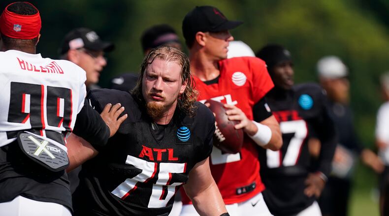 Atlanta Falcons offensive tackle Kaleb McGary (76) protects quarterback Matt Ryan, background, during the team's NFL training camp football practice Monday, Aug. 9, 2021, in Flowery Branch, Ga. (AP Photo/John Bazemore)