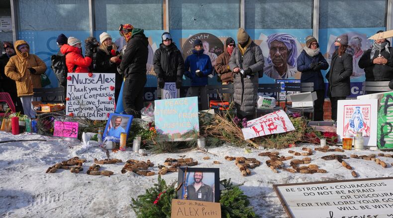 People gather near the scene where Alex Pretti was fatally shot by a U.S. Border Patrol officer yesterday, in Minneapolis, Sunday, Jan. 25, 2026. (AP Photo/Adam Gray)