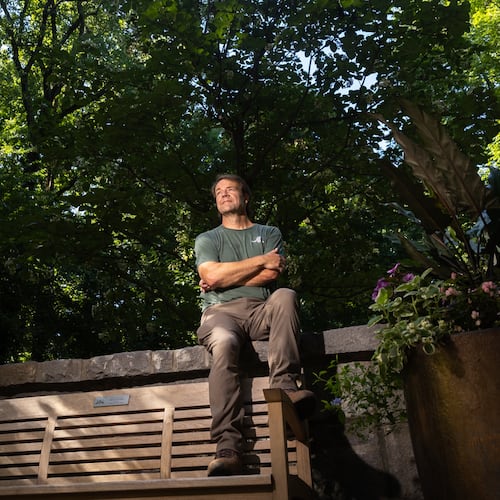 Scott McMahan, vice president of horticulture and collections, sits in front of a rare Chinese emmenopterys henryi tree at Atlanta Botanical Garden. (Arvin Temkar/AJC)