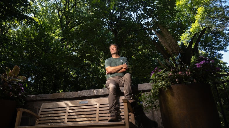 Scott McMahan, vice president of horticulture and collections, sits in front of a rare Chinese emmenopterys henryi tree at Atlanta Botanical Garden. (Arvin Temkar/AJC)
