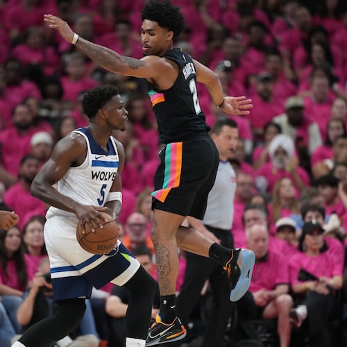 Minnesota Timberwolves guard Anthony Edwards (5) handles the ball as San Antonio Spurs guard Dylan Harper (2) defends during the first half in Game 1 of a second-round NBA playoffs basketball series in San Antonio, Monday, May 4, 2026. (AP Photo/Eric Gay)