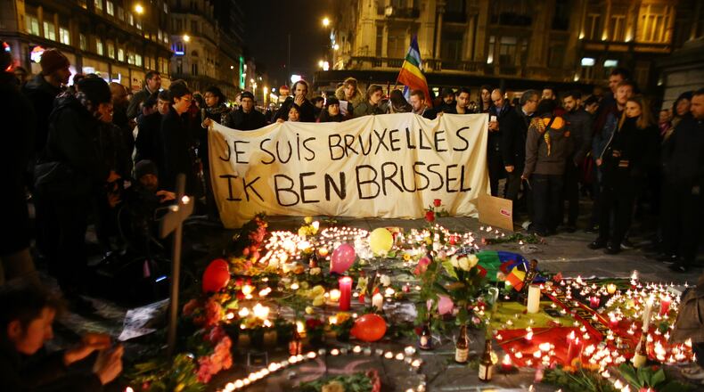 BRUSSELS, BELGIUM - MARCH 22: People hold up a banner as a mark of solidarity at the Place de la Bourse following today's attacks on March 22, 2016 in Brussels, Belgium. At least 31 people are thought to have been killed after Brussels airport and a Metro station were targeted by explosions. The attacks come just days after a key suspect in the Paris attacks, Salah Abdeslam, was captured in Brussels. (Photo by Carl Court/Getty Images)