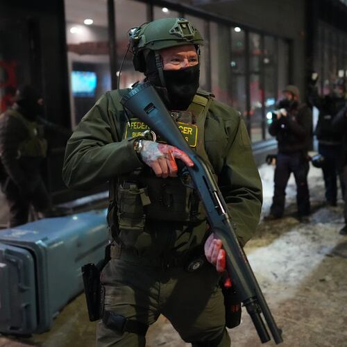 A federal agent stands guard near a hotel during a noise demonstration protest in response to federal immigration enforcement operations in the city Sunday, Jan. 25, 2026, in Minneapolis. (AP Photo/Adam Gray)