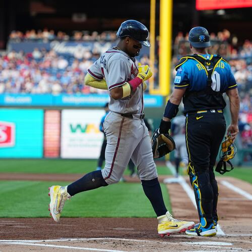 Atlanta Braves' Ronald Acuña Jr. scores past Philadelphia Phillies catcher J.T. Realmuto off of a hit by teammate Ozzie Albies during the first inning of a baseball game, Friday, April 17, 2026, in Philadelphia. (AP Photo/Matt Rourke)