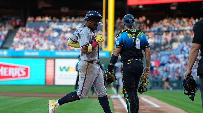 Atlanta Braves' Ronald Acuña Jr. scores past Philadelphia Phillies catcher J.T. Realmuto off of a hit by teammate Ozzie Albies during the first inning of a baseball game, Friday, April 17, 2026, in Philadelphia. (AP Photo/Matt Rourke)