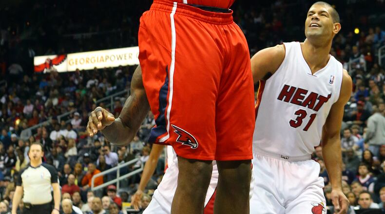 Hawks forward Paul Millsap gets past Heat forward Shane Battier for two of his team-high 26 points during the first half of their NBA basketball game on Monday, Jan. 20, 2014, in Atlanta. CURTIS COMPTON / CCOMPTON@AJC.COM
