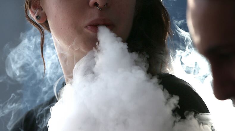 A girl smokes an e-cigarette. A new study recorded a dramatic uptick in the numbers of teenagers vaping nicotine in the past year. Experts are worried about the health affects.
