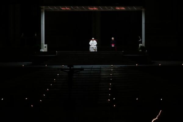 FILE - Pope Francis is flanked by Mons. Guido Marini, right, the Vatican master of liturgical ceremonies, as he leads the Via Crucis – or Way of the Cross – ceremony in St. Peter's Square empty of the faithful following Italy's ban on gatherings to contain coronavirus contagion, at the Vatican, Friday, April 10, 2020. (AP Photo/Alessandra Tarantino, File)