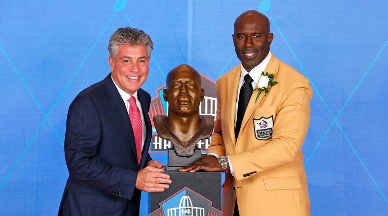 Terrell Davis, right, poses with his bust and with presenter and agent Neil Schwartz, during inductions at the Pro Football Hall of Fame, Saturday, Aug. 5, 2017, in Canton, Ohio. (AP Photo/Gene J. Puskar)