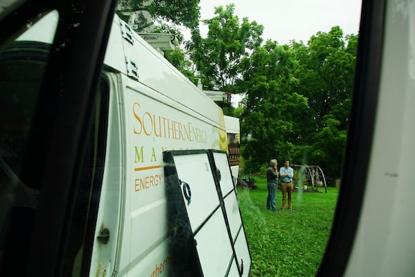 James Asbill, left, speaks with Will Etheridge, CEO of Southern Energy Management, as solar panels are installed on Asbill's home in Chapel Hill, N.C., Wednesday, July 2, 2025. (AP Photo/Allen G. Breed)