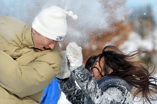 Patrick Kim (left) and Yoojin Park enjoy a snowball fight at Town Center Park in Suwanee on January 29, 2014. (HYOSUB SHIN / hshin@ajc.com)