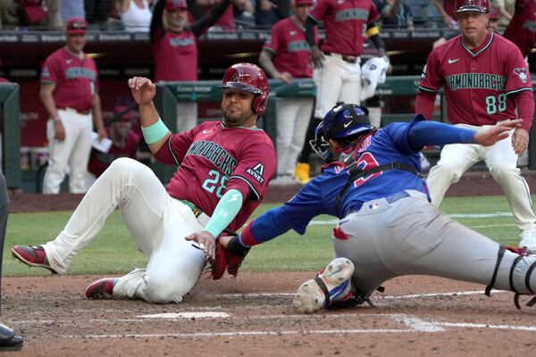Arizona Diamondbacks' Eugenio Suárez (28) is tagged out by Chicago Cubs catcher Miguel Amaya, front right, on a ball hit by Ryne Nelson in the eighth inning during a baseball game, Sunday, March 30, 2025, in Phoenix. (AP Photo/Rick Scuteri)
