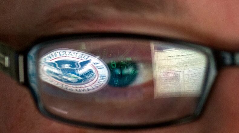 FILE - In this Sept. 30, 2011, file photo, a reflection of the Department of Homeland Security logo is seen reflected in the glasses of a cyber security analyst in the watch and warning center at the Department of Homeland Security's secretive cyber defense facility at Idaho National Laboratory in Idaho Falls, Idaho. Through history, the United States has relied on its borders and superior military might to protect against and deter foreign aggressors. But a lack of boundaries and any rulebook in cyberspace has increased the threat and leveled the playing field today. (AP Photo/Mark J. Terrill, File)