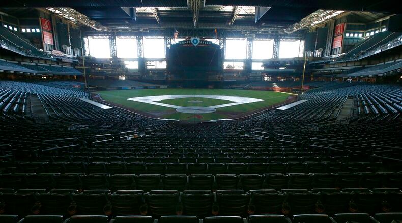 In this Tuesday, April 28, 2020, file photo, a darkened Chase Field, home of the Arizona Diamondbacks of baseball's National League, sits empty. (AP Photo/Ross D. Franklin, File)
