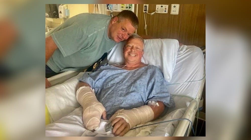 Police officer Jay Hood visits his friend Chad Wombles, a Wrightsville firefighter, in the hospital days after Wombles was attacked by a man with a sword. Doctors have reattached Wombles' hand. (Courtesy photo)