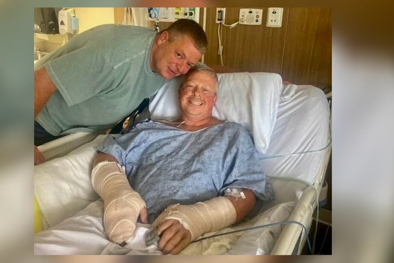 Police officer Jay Hood visits his friend Chad Wombles, a Wrightsville firefighter, in the hospital days after Wombles was attacked by a man with a sword. Doctors have reattached Wombles' hand. (Courtesy photo)