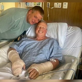 Police officer Jay Hood visits his friend Chad Wombles, a Wrightsville firefighter, in the hospital days after Wombles was attacked by a man with a sword. Doctors have reattached Wombles' hand. (Courtesy photo)