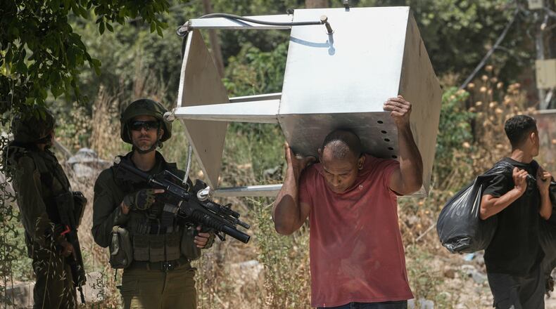 Palestinians collect their belongings from their evacuated homes after the Israeli army issued a number of short term access permits for residents of the occupied West Bank refugee camp of Tulkarem, Wednesday, June 17, 2026. (AP Photo/Majdi Mohammed)