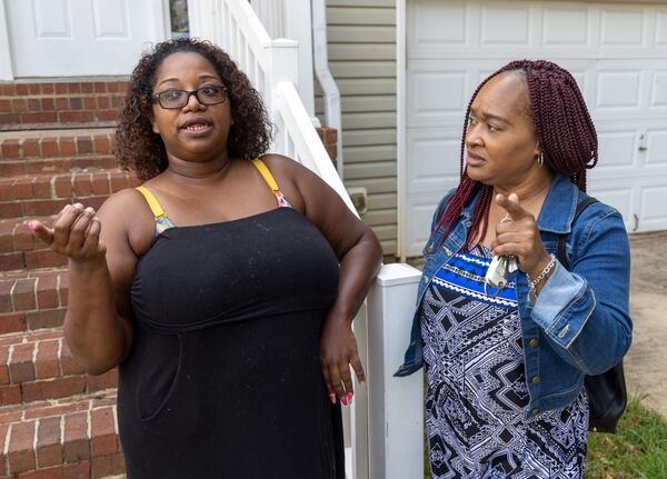 Ebon Sledge (left) talks with Cherie DeBose, program coordinator with Opens Doors, who helped Sledge get their new rental home for her and her eight children. PHIL SKINNER FOR THE ATLANTA JOURNAL-CONSTITUTION