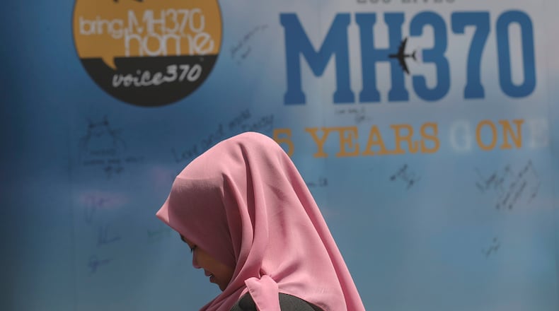 FILE - A girl stands in front of a condolence message board during a Day of Remembrance for MH370 event in Kuala Lumpur, Malaysia, on March 3, 2019. (AP Photo/Vincent Thian, File)