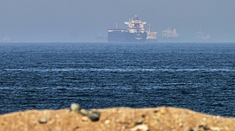 Cargo ships are seen at sea near the Strait of Hormuz, as viewed from a rocky shoreline near Khor Fakkan, United Arab Emirates, Friday, May 1, 2026. (AP Photo/Fatima Shbair)