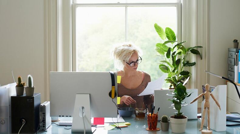 A woman looks at documents in a home office