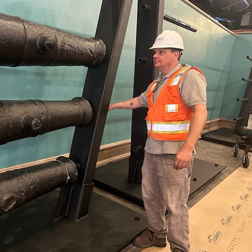 Terry Koeller inspects cannons, which sunk to the bottom of the Savannah River during the American Revolution, on a rack at the Savannah History Museum in Savannah, Ga., on Wednesday, June 3, 2026. (AP Photo/Russ Bynum)