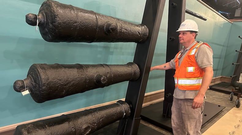 Terry Koeller inspects cannons, which sunk to the bottom of the Savannah River during the American Revolution, on a rack at the Savannah History Museum in Savannah, Ga., on Wednesday, June 3, 2026. (AP Photo/Russ Bynum)