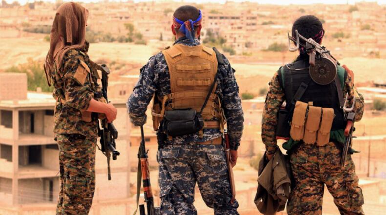 FILE - This April 30, 2017, file photo provided by the Syrian Democratic Forces (SDF) shows fighters from the SDF looking toward the northern town of Tabqa, Syria. The U.S.-led coalition headquarters in Iraq said in a written statement that a U.S. F-18 Super Hornet shot down a Syrian government SU-22 on Sunday, June 18, after it dropped bombs near the U.S. partner forces, known as the Syrian Democratic Forces. The shootdown was near the Syrian town of Tabqa. (Syrian Democratic Forces via AP, File)