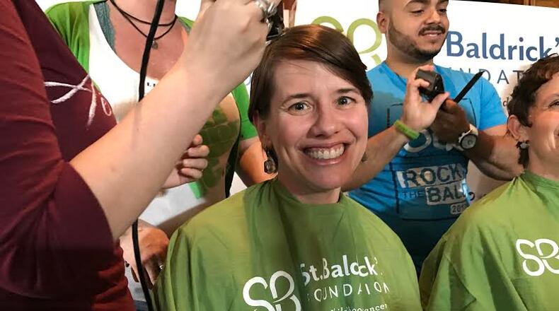 Elyse Bryson gets her head shaved to raise money for childhood cancer research.Photo by HELENA OLIVIERO/HOLIVIERO@AJC.COM
