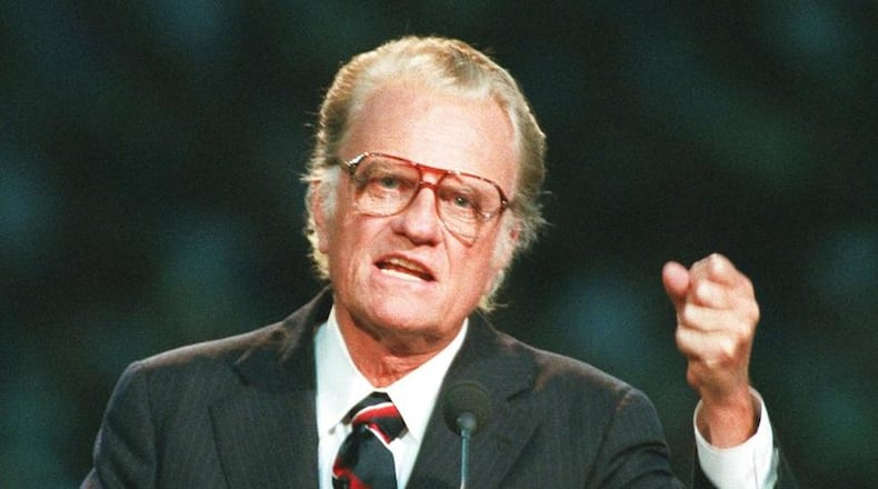 In this Oct 26, 1994 file photo, Evangelist Billy Graham begins his sermon in Atlanta's Georgia Dome. Graham, who transformed American religious life through his preaching and activism, becoming a counselor to presidents and the most widely heard Christian evangelist in history, has died. Spokesman Mark DeMoss says Graham, who long suffered from cancer, pneumonia and other ailments, died at his home in North Carolina on Wednesday, Feb. 21, 2018. He was 99. AP Photo/John Bazemore, File