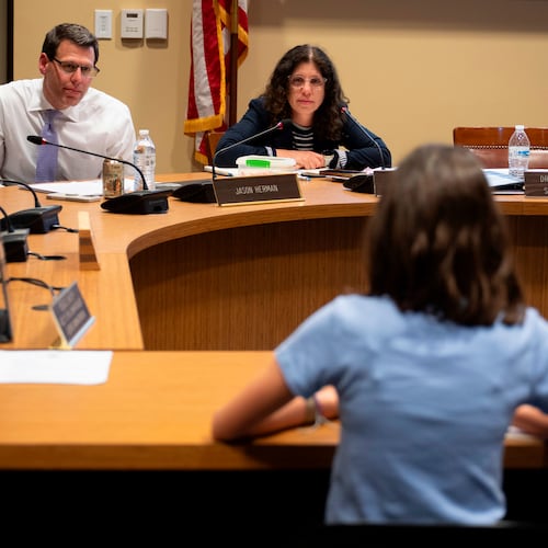 Members of the Lower Merion Board of School Directors speak with a student at a school board meeting on Monday, May 11, 2026, in Ardmore, Pa. (AP Photo/Joe Lamberti)