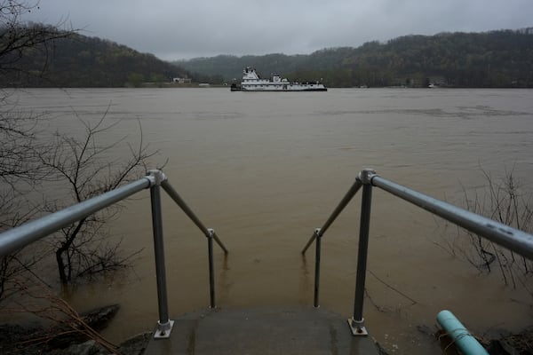 Stairs vanish into the rising Ohio River in front of Drew's on the River Sports Bar and Grill, Friday, April 4, 2025, in Cincinnati. (AP Photo/Carolyn Kaster)