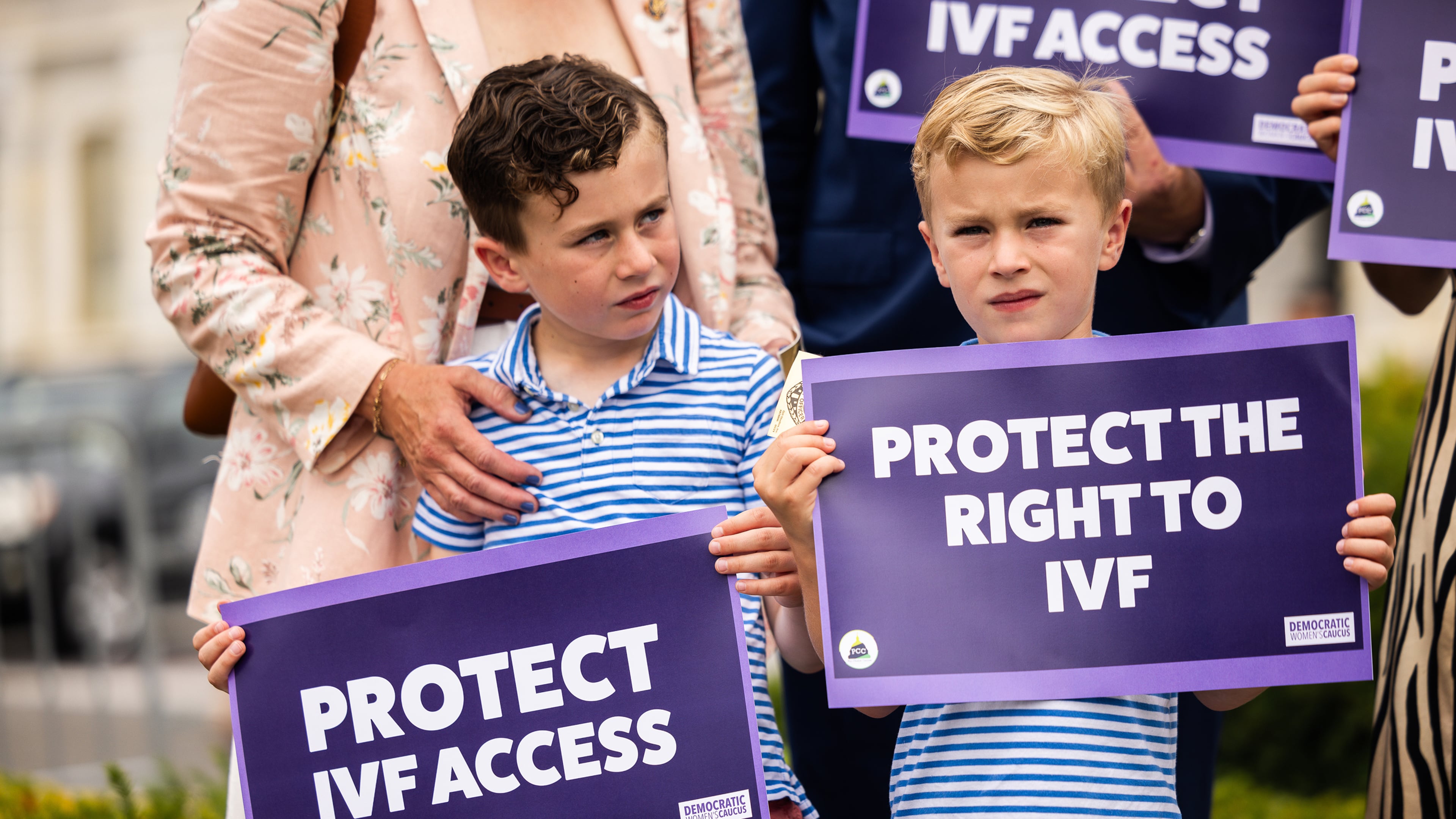 Liam Mullin, left, and Landon Mullin, the sons of Rep. Kevin Mullin (D-CA), hold signs during a news conference in honor of World IVF Day to discuss the next steps for legislation to protect access to in vitro fertilization across America, on July 25, 2024, in Washington, D.C. (Tierney L. Cross/Getty Images/TNS)
