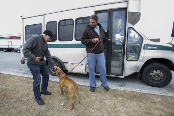 Charlie Kleman says goodbye to Lacy, who is taken by Tim Sandford of Grateful Doggies transportation. Lacy will travel to her new adopted home in New Jersey. MIGUEL MARTINEZ FOR THE ATLANTA JOURNAL-CONSTITUTION