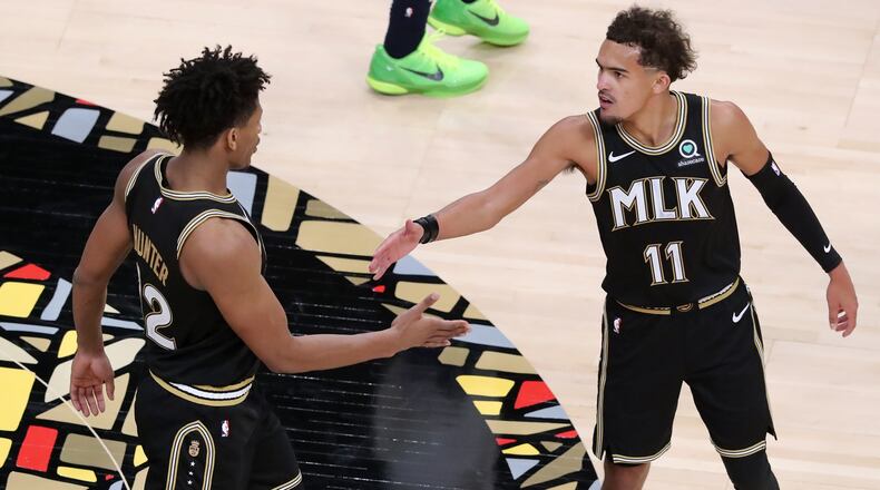 Atlanta Hawks guard Trae Young and forward De’Andre Hunter celebrate a 108-97 victory over the Minnesota Timberwolves in the MLK Day Unity game Monday, Jan. 18, 2021, at State Farm Arena in Atlanta. The Rev. Dr. Martin Luther King Jr.'s hometown honored the civil-rights icon with jerseys featuring the letters “MLK” - a first in the NBA. (Curtis Compton / Curtis.Compton@ajc.com)